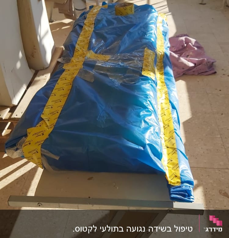 שקית כחולה עם סרט דבק צהוב על שולחן